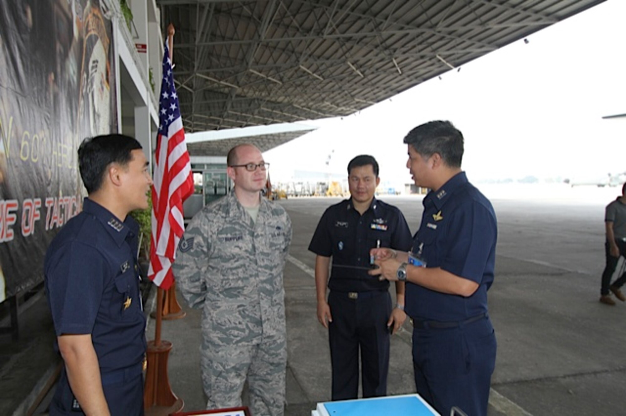 Tech. Sgt. Erik Ruppert presents a 373 Training SquadronDetachment 4 coin to 601 Squadron Commander, Wing Commander (O-5) Saraphongse Dibavadi (far right) Also pictured are RTAF Wing 6 Deputy Commander, Group Commander (0-6) Porndech Khongpan (far left) and RTAF 601 Chief of Maintenance, Squadron Leader (0-4) Natchanon Wongwenai (center).  A team of three U.S. Air Force C-130 aircraft maintainers from Little Rock Air Force Base’s mobile training team embarked on a two-week training partnership with the Royal Thai Air Force in Bangkok, Thailand. (U.S. Air Force photo by Capt. Steve Massara)    