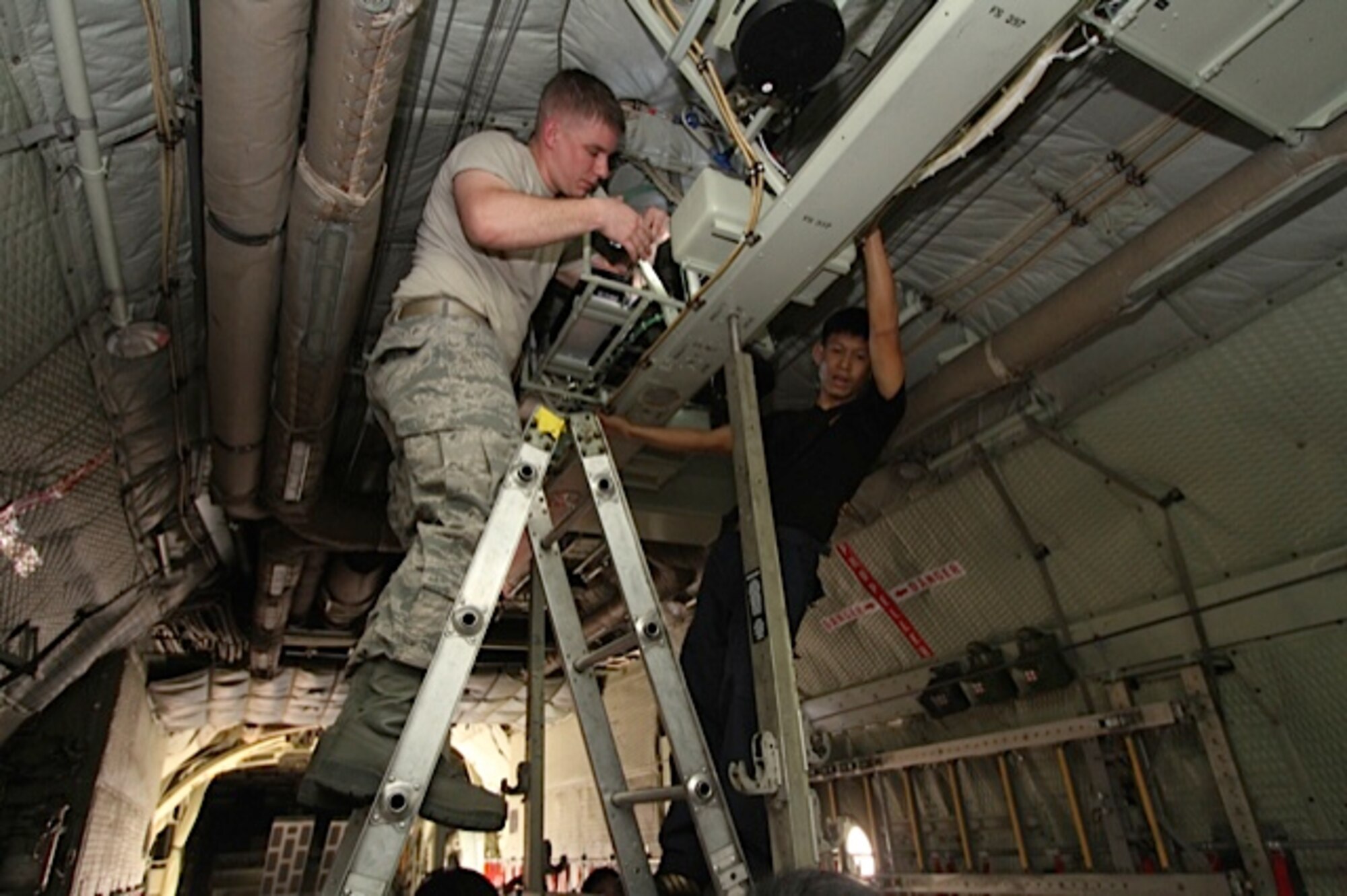 Staff Sgt. Jeremy Burkey and a Royal Thai Air Force airframe specialist check the rigging on the C-130’s throttles. A team of three U.S. Air Force C-130 aircraft maintainers from Little Rock Air Force Base’s mobile training team embarked on a two-week training partnership with the Royal Thai Air Force in Bangkok, Thailand. (U.S. Air Force photo by Capt. Steve Massara)    