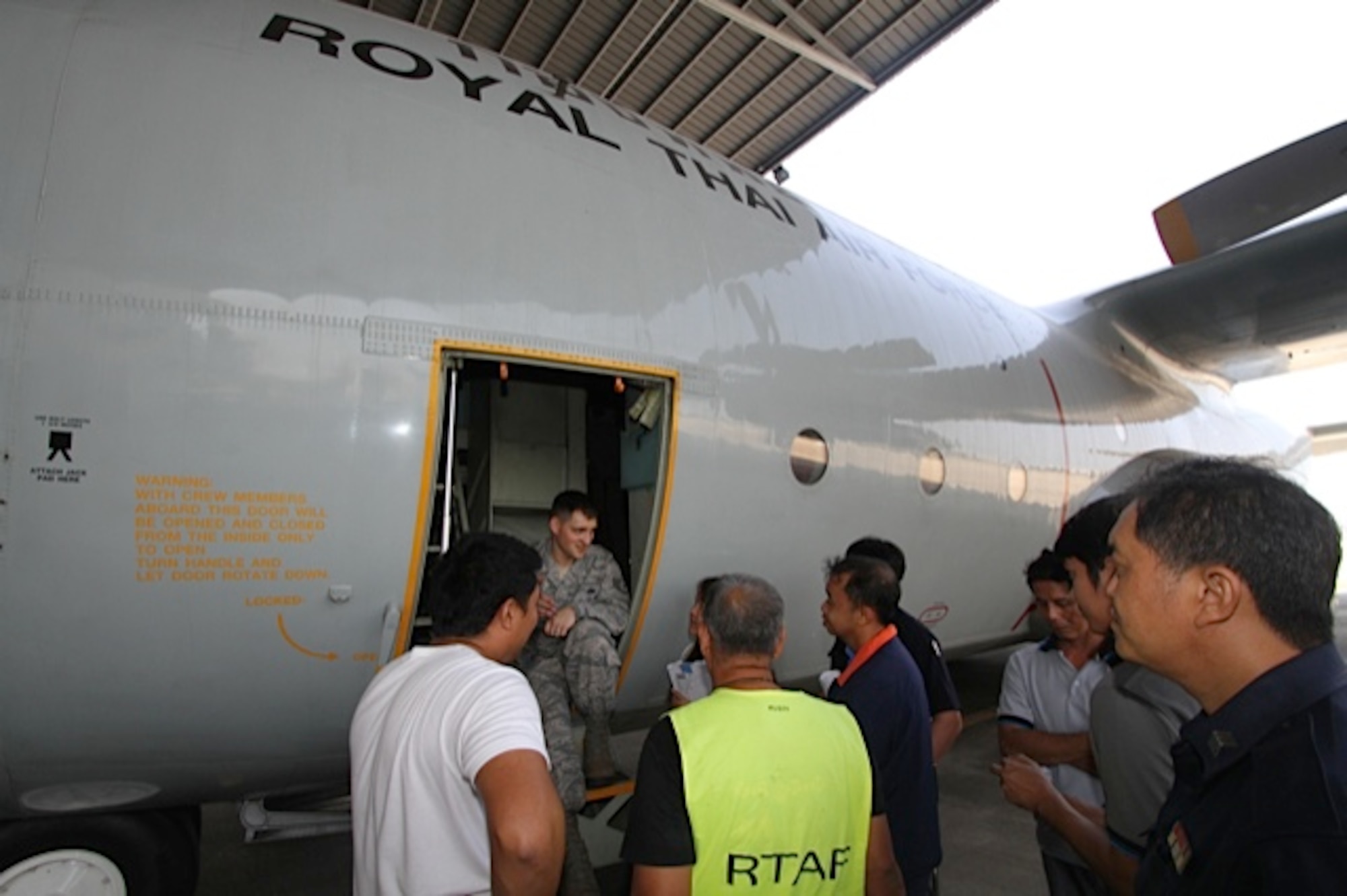 Staff Sgt. Chase Honeycutt presents the theory behind adjusting the crew entrance door. A team of three U.S. Air Force C-130 aircraft maintainers from Little Rock Air Force Base’s mobile training team embarked on a two-week training partnership with the Royal Thai Air Force in Bangkok, Thailand. (U.S. Air Force photo by Capt. Steve Massara)    