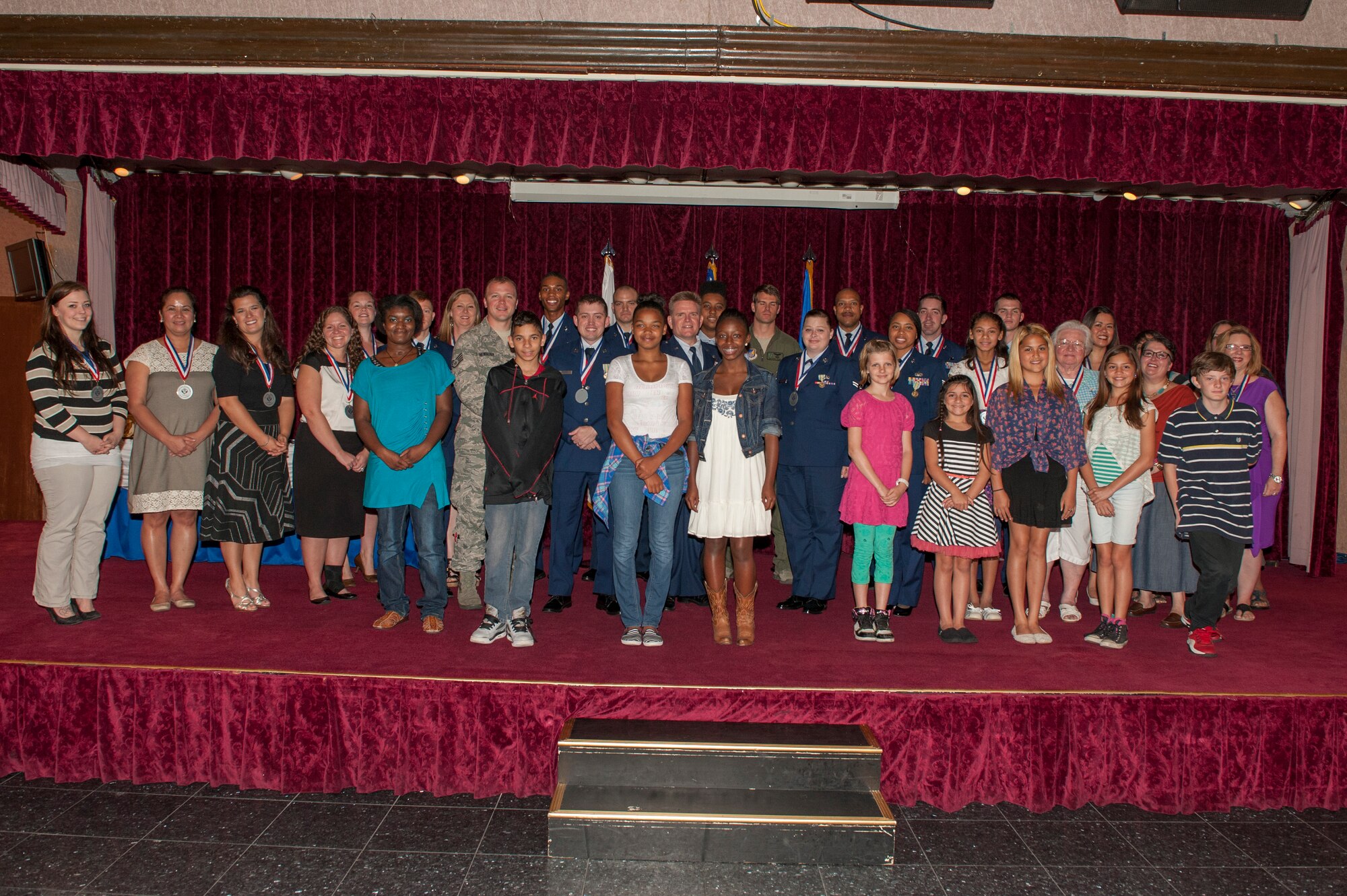 The award winners from the annual volunteer recognition ceremony pose for a group photo at the Rocker NCO club on Kadena Air Base, Japan, April 17, 2015. In the past year, volunteers have offered more than 620,148 hours of their own time to help various organizations and causes throughout the base and local community. (U.S. Air Force photo by Airman 1st Class Stephen G. Eigel)