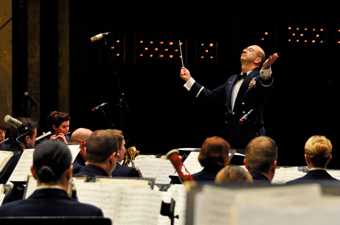 U.S. Air Force Maj. Bryan M. Miller, commander of the 566th Air Force Band, conducts the band at the Illinois Music Educators Association conference opening night in Peoria, Ill., Jan. 28, 2015. The 566 AFB serves in war and peace by preserving national heritage through the power of music at military, recruiting and community relations events. (U.S. Air National Guard photo by Staff Sgt. Lealan Buehrer/Released)
