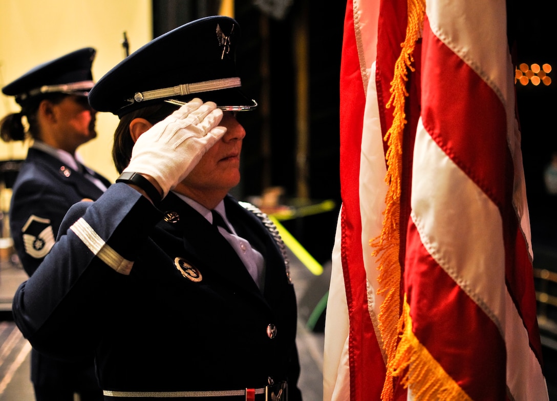 U.S. Air Force Chief Master Sgt. Diana L. Braun, a color guard member with the 183rd Force Support Squadron, salutes after posting the American flag at the Illinois Music Educators Association conference opening night in Peoria, Ill., Jan. 28, 2015. The 566th Air Force Band performed immediately after as part of its mission to preserve national heritage through the power of music at military, recruiting and community relations events. (U.S. Air National Guard photo by Staff Sgt. Lealan Buehrer/Released)