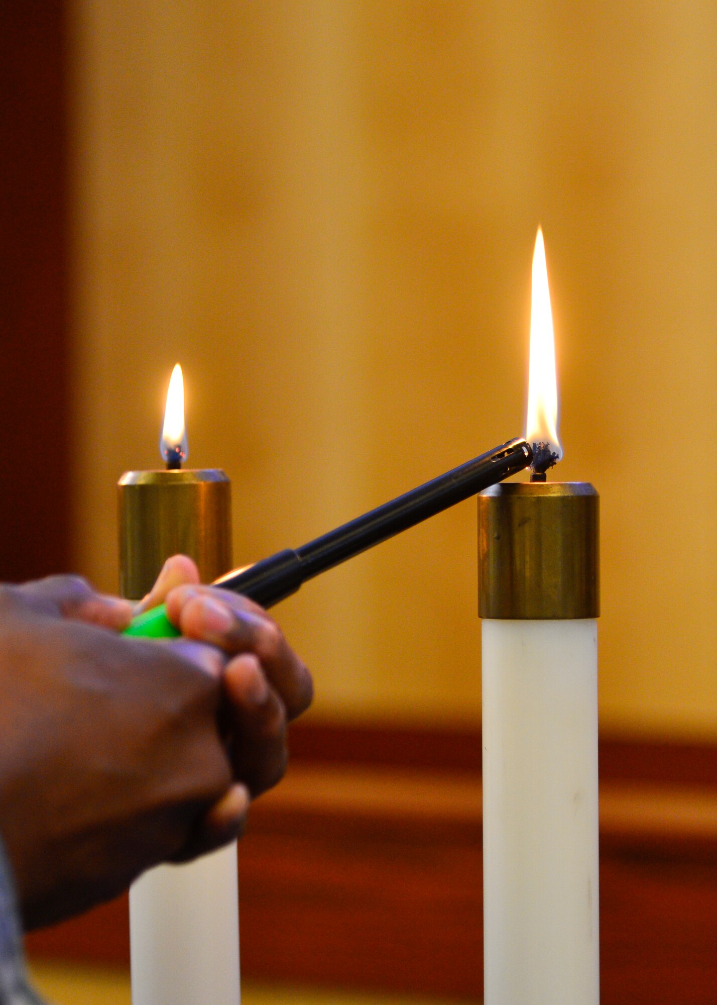 Master Sgt. Richard Matthews Jr., 436th Medical Operations Squadron Mental Health flight chief, lights a candle during the Holocaust Remembrance Observance April 16, 2015, at Chapel 1 on Dover Air Force Base, Del. Six candles were lit to represent the six million Jews killed during the Holocaust. (U.S. Air Force photo/Airman 1st Class William Johnson)
