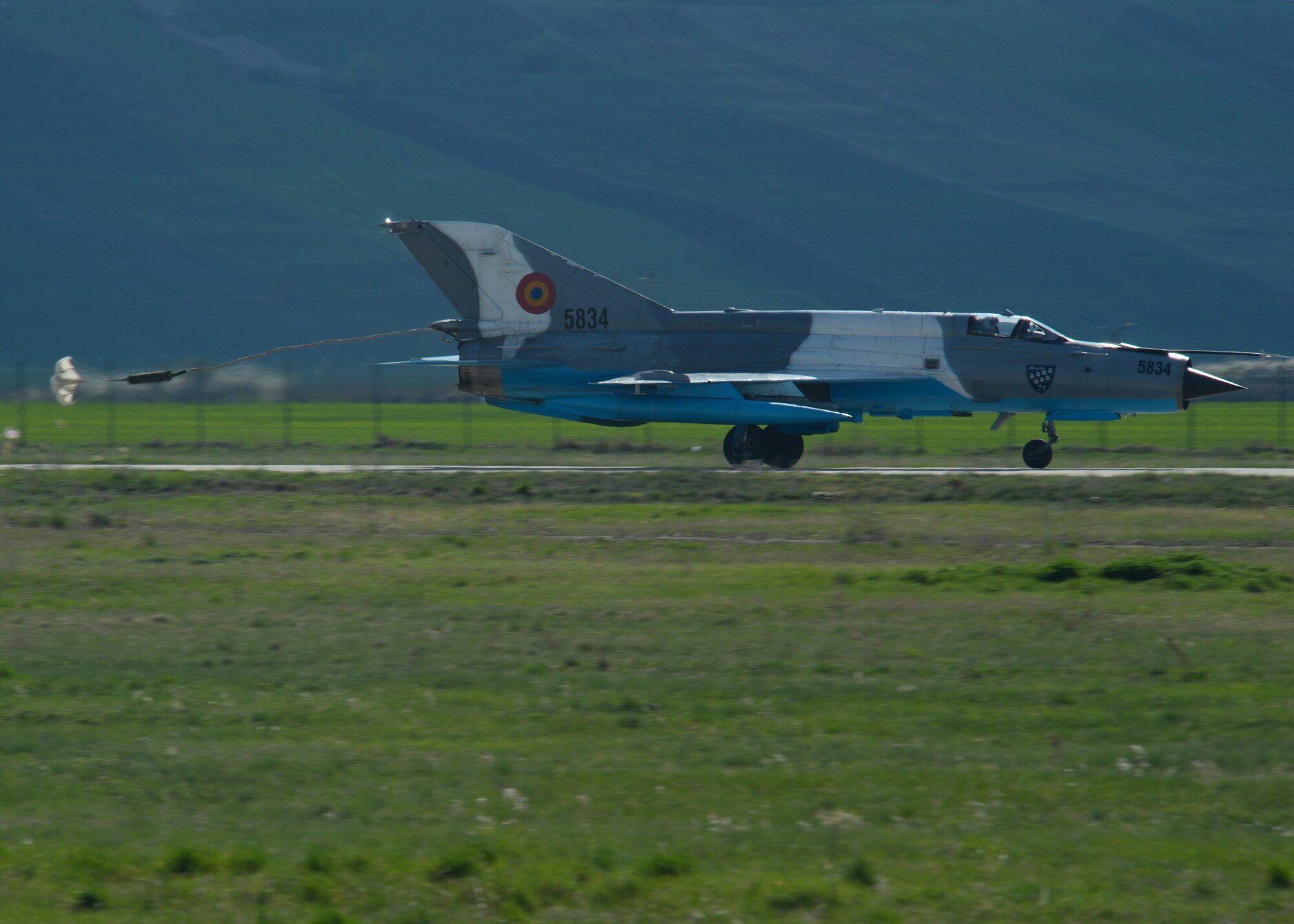A Romanian air force MiG-21 fighter aircraft assigned to the 71st Air Base deploys its parachute upon landing on the flightline at Campia Turzii, Romania, April 16, 2015. The U.S. and Romanian air forces will conduct training aimed to strengthen interoperability and demonstrate the countries' shared commitment to the security and stability of Europe. (U.S. Air Force photo by Staff Sgt. Joe W. McFadden/Released)