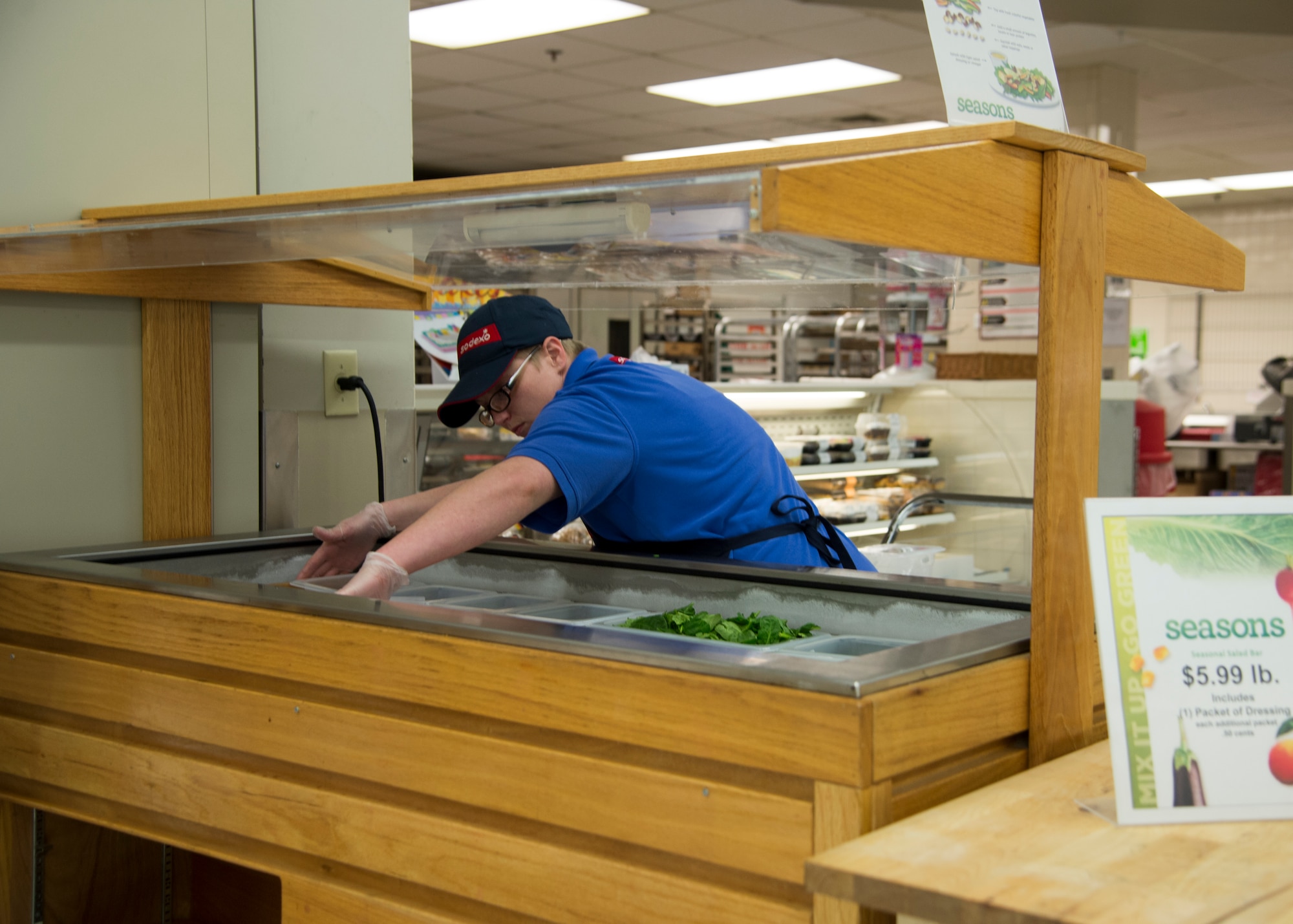 Tanya Fernwalt, Dover Air Force Base Commissary deli/bakery clerk, stocks the newly installed salad bar April 17, 2015, at the Commissary on Dover AFB, Del. The salad bar is operated Tuesday through Friday from 10 a.m. to 2 p.m. and features 18 different items. (U.S. Air Force photo/Airman 1st Class William Johnson)