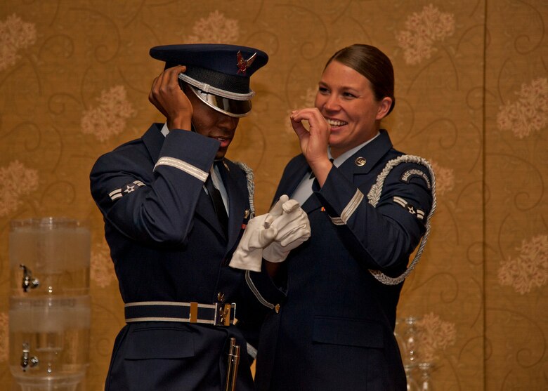 PETERSON AIR FORCE BASE, Colo. – Airmen 1st Class Khalil Davis and Rosemary Gudex, High Frontier Honor Guard ceremonial guardsmen, help each other prepare their uniforms before an event April 8, 2015. The High Frontier Honor Guard attends various events including presenting the colors for official events, retirements and military funerals. The unit’s area of responsibility includes Colorado, Kansas, Utah and Wyoming. (U.S. Air Force photo by Senior Airman Tiffany DeNault)