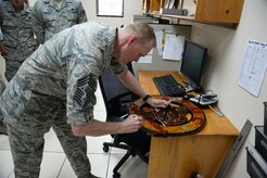 Chief Master Sgt. James A. Cody autographs the “Port Dawg” emblem of the air tactical operations center during a visit April 14, 2015, at Joint Task Force - Bravo, Soto Cano Air Base, Honduras. Cody visited multiple units on base during his time here, mentoring and engaging with Airmen from a senior leader perspective. (U.S. Air Force photo by Staff Sgt. Jessica Condit)