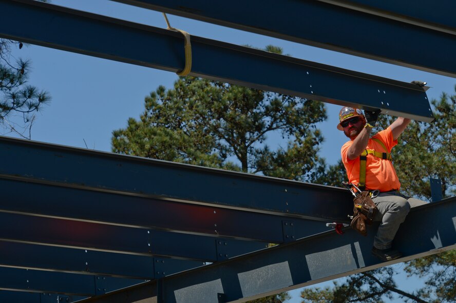 Steve Clemons, Charleston Building Company iron worker, grabs ahold of a purlin during construction of the Combat Arms building at Shaw Air Force Base, S.C., March 31, 2015. The building is being reconstructed to make it a safer place for instructors and trainees, circulating the air and clearing the lead. (U.S. Air Force photo by Senior Airman Tabatha Zarrella/Released)