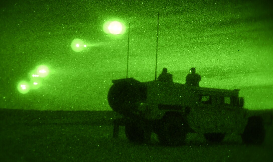 U.S. Army Soldiers from the 2nd Brigade Combat Team, 82nd Airborne Division, look on as parajumpers are released from C-130J Super Hercules April 13, 2015, at Fort Bragg, North Carolina. On hit-night for Combined Joint Operational Access Exercise 15-01, U.S. Air Force and British Royal Air Force aircraft dropped 2,100 parajumpers from the 82nd Airborne Division and British Army 16th Air Assault Brigade. Together, the forces seized a drop zone, which was under simulated enemy control. (U.S. Air Force photo by Senior Airman Peter Thompson/Released)