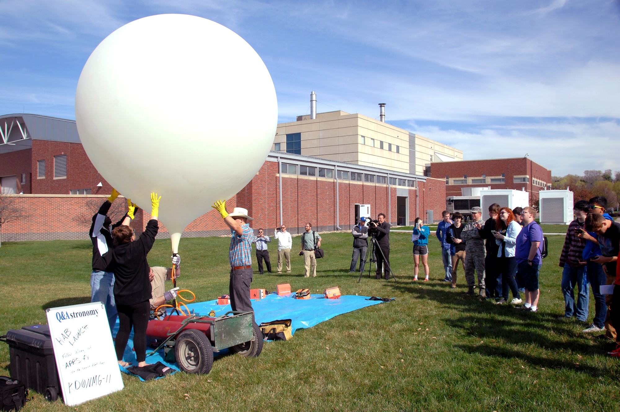 Project HALON, or High Altitude Learning over Nebraska, participants prepare a weather balloon for launch outside of the Peter Kiewit Institute at the University of Nebraska at Omaha campus April 14, 2015. The weather balloon will carry five sensor packages up to an altitude of 80-100 thousand feet, collecting meteorological data along the way. (U.S. Air Force photo by Delanie Stafford/Released)