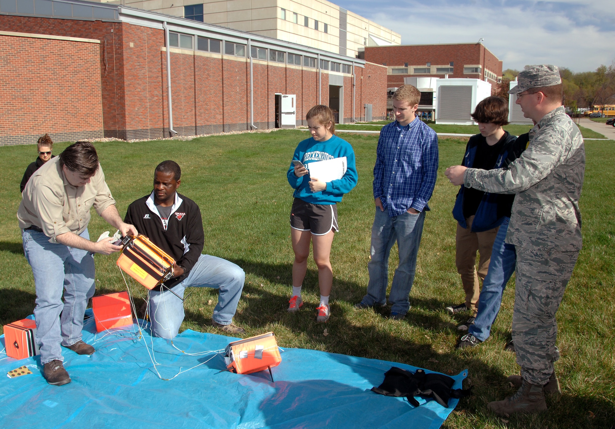 Students from Bellevue West High School and other Project HALON, or High Altitude Learning over Nebraska, participants look on as University of Nebraska at Omaha staff members connect sensor packages together April 14, 2015. They were attached to a weather balloon and launched from UNO’s campus. (U.S. Air Force photo by Delanie Stafford/Released)