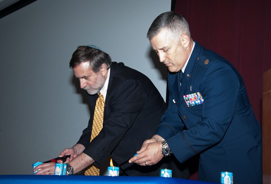 Rabbi Scott Kramer, Agudath Israel Etz Ahayem Synagogue spiritual leader, and Chap. (Maj.) Travis Yelton, 42nd Air Base Wing chaplain, light memorial candles at the Holocaust Days of Remembrance Commemoration ceremony, April 14, 2015, Maxwell Air Force Base, Alabama. Eight memorial candles were lit to honor the lives lost during the Holocaust. (U.S. Air Force photo by Henry Hancock/Cleared)