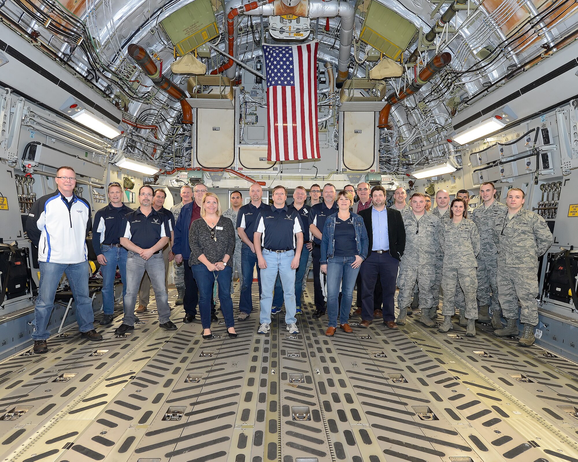 The 2015 Dover Air Force Base Honorary Commanders and military personnel pose inside the cargo compartment of a C-17A Globemaster III of the 436th Airlift Wing, 512th AW, Air Force Reserve Command, during a tour of the 436th Maintenance Group April 15, 2015, on Dover Air Force Base, Del. An American flag hangs in the background. The C-17A was opened up for the tour to showcase the innovative maintenance procedures and ease of access built in to the aircraft.  (U.S. Air Force photo/Greg L. Davis)