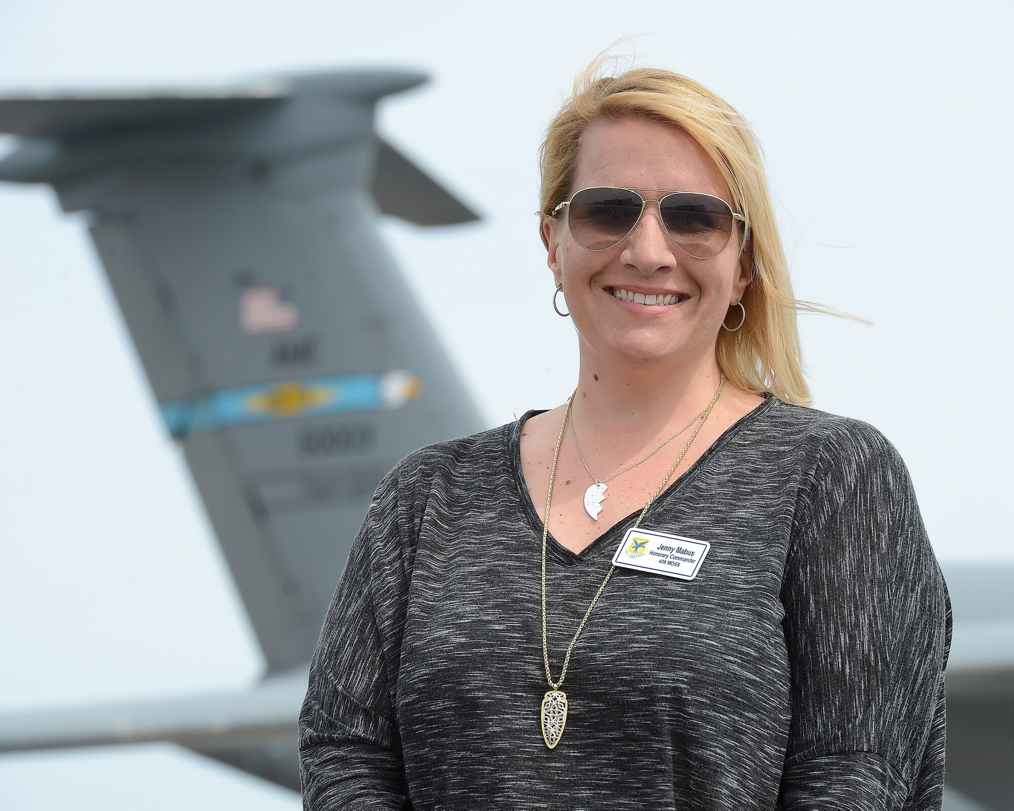 Jenny Mabus, 436th Medical Support Squadron honorary commander, poses on the Dover Air Force Base flight line with the tail of a C-5M Super Galaxy visible in the background during the 2015 Dover Air Force Base Honorary Commanders tour of the 436th Maintenance Group April 15, 2015, on Dover AFB, Del. The tour provided insight in to the operational capabilities of the 436th Airlift Wing. (U.S. Air Force photo/Greg L. Davis)