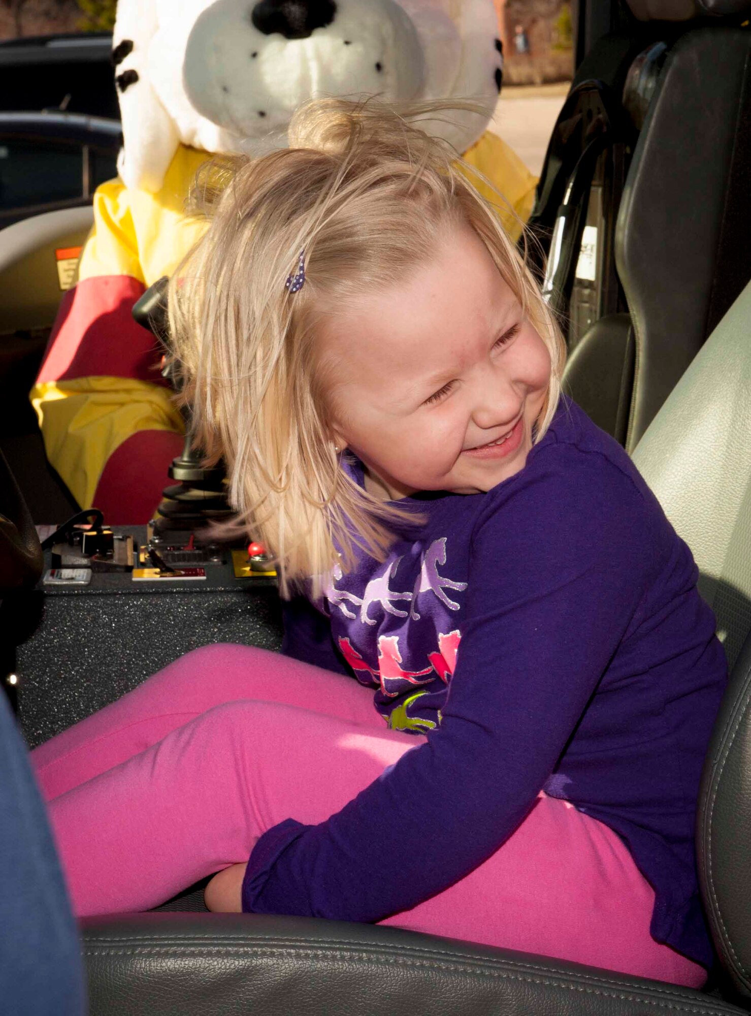 Blakeley Shepherd, age 4, giggles while sitting in the front seat of a fire truck on Minot Air Force Base, N.D., April 15, 2015. Along with free bowling and face painting, the children were able to visit with the fire department. (U.S. Air Force photo/Airman 1st Class Sahara L. Fales)