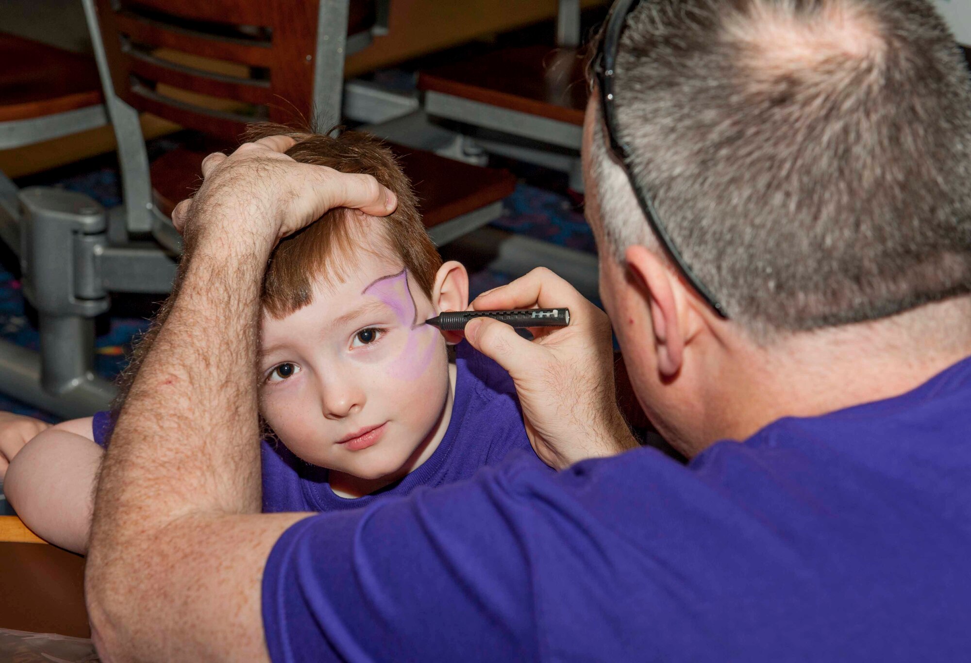Staff Sgt. Matthew Cremeans, 5th Aircraft Maintenance Squadron mobility assistance, paints his son’s face during a military kids’ celebration on Minot Air Force Base, N.D., April 15, 2015. In honor of the month of the military child, face painting and free bowling were offered at Rough Rider Lanes. (U.S. Air Force photo/Airman 1st Class Sahara L. Fales)