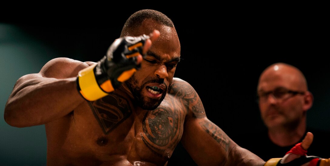 U.S. Air Force Tech. Sgt. Clinton Williams, 52nd Component Maintenance Squadron engine manager, claps his hands after he claims victory against his opponent, Raymond Jarman, a mixed martial artist from Amsterdam, during the 12th Kwon Respect Fighting Championship in Wuppertal, Germany, April 11, 2015. Williams defended against Jarman’s attacks, returned a few kicks and rendered Jarman unconscious with a single punch to the jaw. (U.S. Air Force photo by Airman 1st Class Timothy Kim/Released)