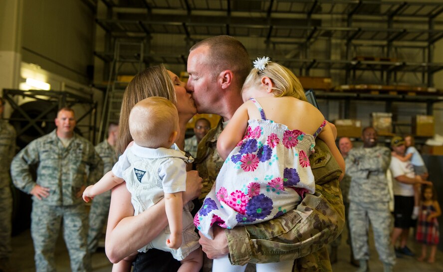 U.S. Air Force Staff Sgt. Jonathan Rhodes, 23d Logistics Readiness Squadron, embraces his family during his surprise redeployment April 14, 2015, at Moody Air Force Base, Ga. Rhodes deployed to Bagram Airfield, Afghanistan for six months. (U.S. Air Force photo by Airman 1st Class Ceaira Tinsley/Released)