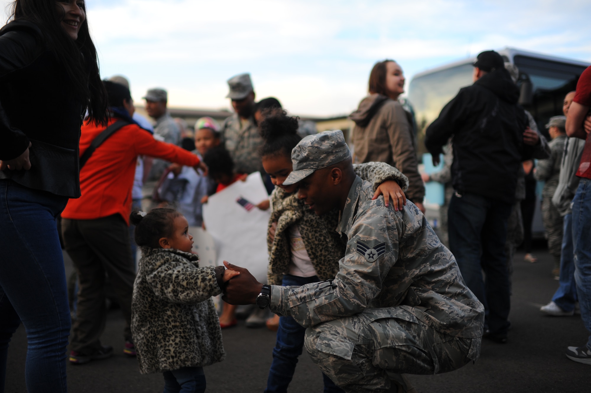 An Airman from the 606th Air Control Squadron greets his daughters during a deployment homecoming on Spangdahlem Air Base, Germany, April 17, 2015. More than 80 U.S. Air Force Airmen assigned to the 606th ACS returned home at the event. (U.S. Air Force photo by Senior Airman Gustavo Castillo/Released) 
