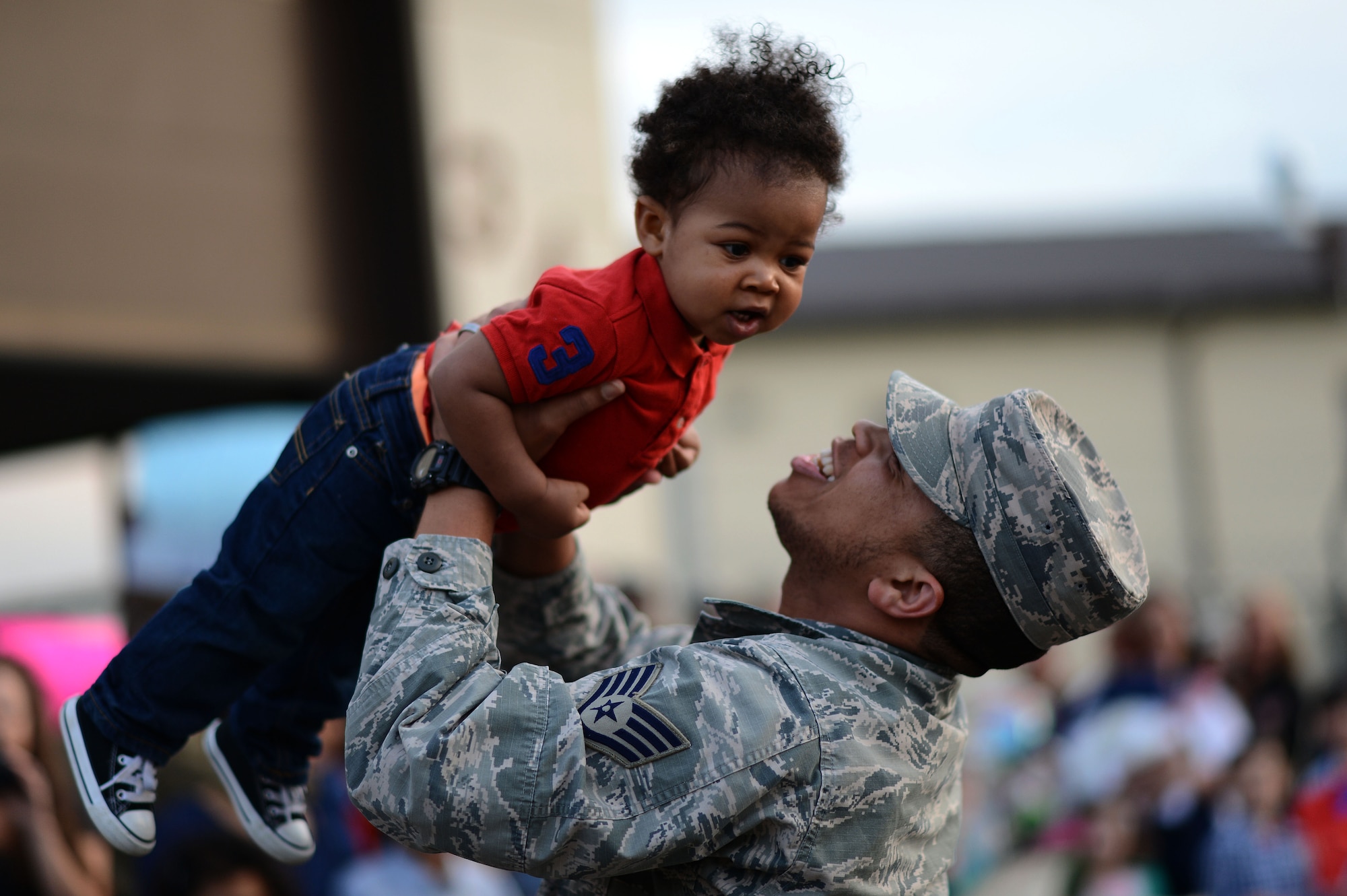 An Airman from the 606th Air Control Squadron picks up his son during a deployment homecoming on Spangdahlem Air Base, Germany, April 17, 2015. Families and friends had several minutes to celebrate the deployed member’s arrival before a quick speech from the squadron commander releasing them for the weekend. (U.S. Air Force photo by Senior Airman Gustavo Castillo/Released) 