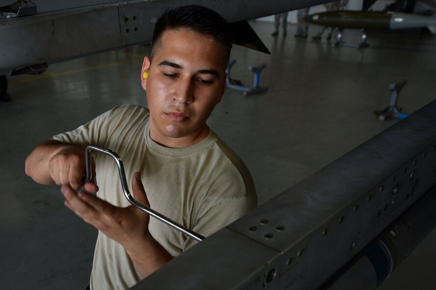 U.S. Air Force Airman 1st Class Omar Hurtado, 20th Aircraft Maintenance Squadron weapons technician, tightens a bolt during a load crew of the year competition at Shaw Air Force Base, S.C., April 17, 2015. Hurtado worked with two other Airmen to load munitions onto an F-16CM Fighting Falcon as quickly as possible in an effort to win the competition. (U.S. Air Force photo by Airman 1st Class Michael Cossaboom/Released)