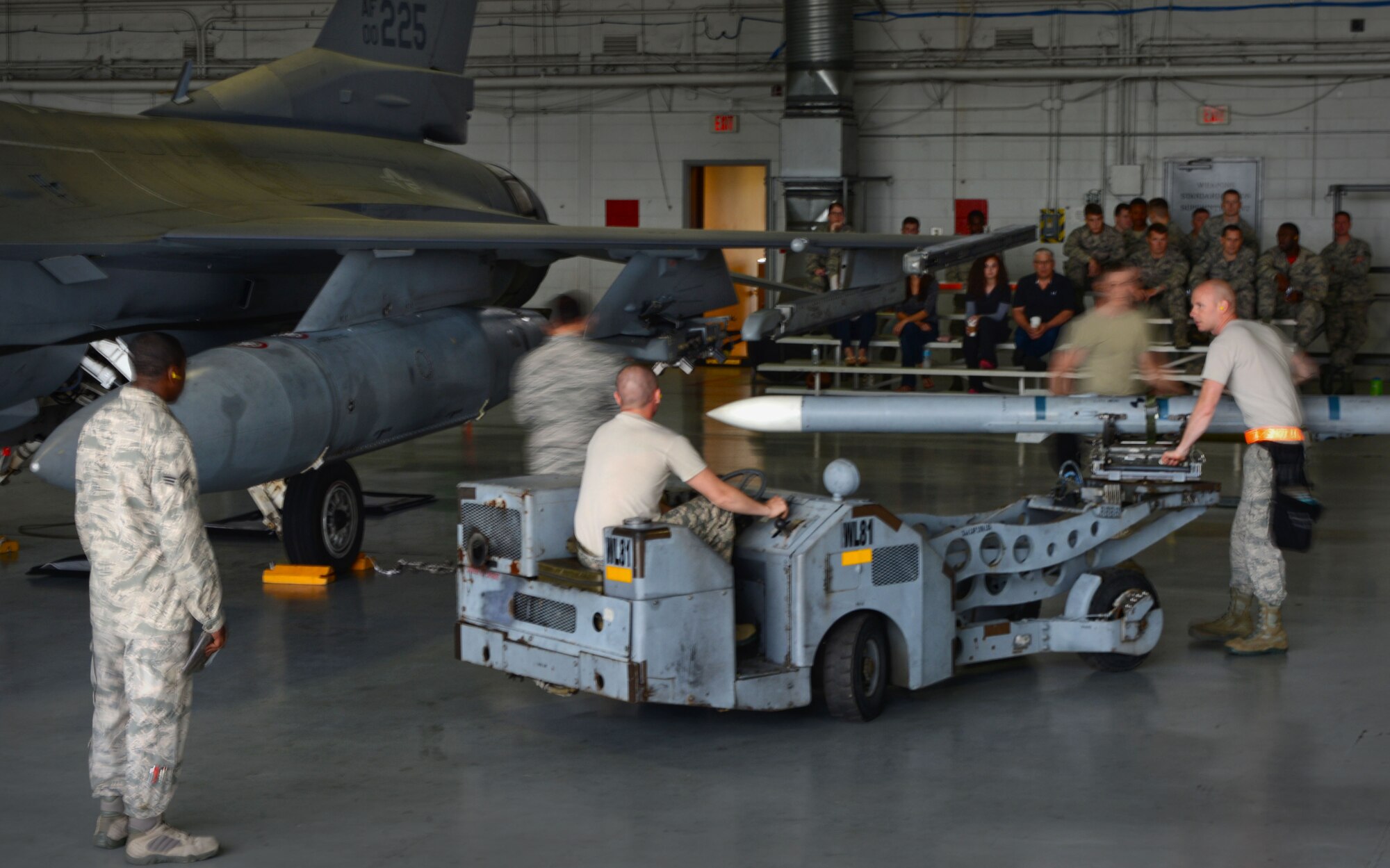 U.S. Air Force Airmen participate in a load crew of the year competition at Shaw Air Force Base, S.C., April 17, 2015. Throughout the competition, four teams assigned to the 20th Fighter Wing competed against the clock to load four munitions onto an F-16CM Fighting Falcon. (U.S. Air Force photo by Senior Airman Jensen Stidham/Released)