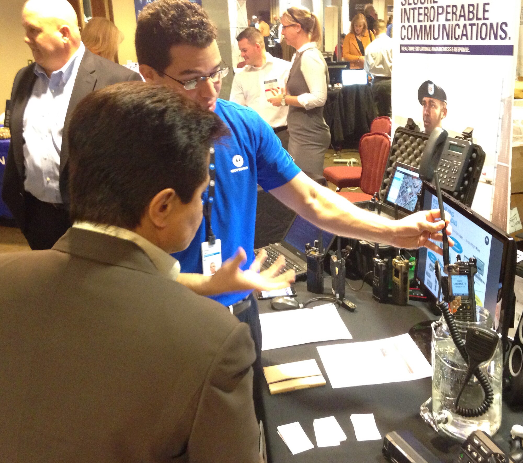 PETERSON AIR FORCE BASE, Colo. -- Daniel Zada, Tech & Space Ops Support Showcase vendor, demonstrates how a handheld radio still works, even when submerged underwater for significant periods of time. More than 30 technology and tech-related vendors descended on Peterson Air Force Base April 14 to display their wares and meet customers at the Tech & Space Ops Support Showcase held at The Club. (U.S. Air Force photo by Dave Smith)