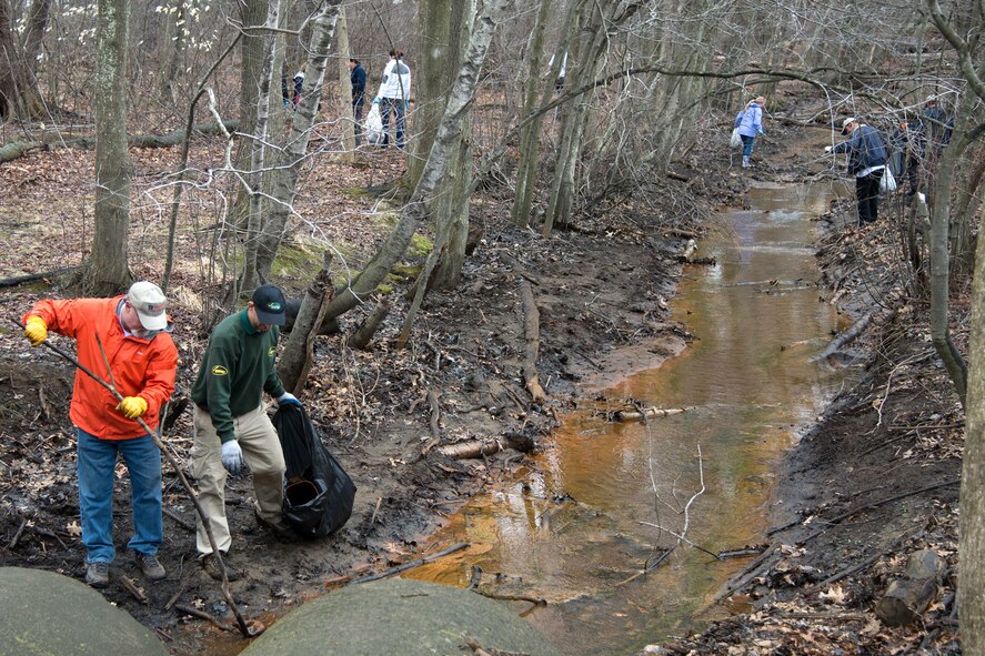 Several volunteers collect trash from the Shawsheen River April 17 as part of an Earth Day River Cleanup project on base. Several volunteers from the base community, as well as sixth graders from the Hanscom Middle School, removed more than 17 bags of trash and debris from the river and the surrounding area. (U.S. Air Force photo by Mark Herlihy)