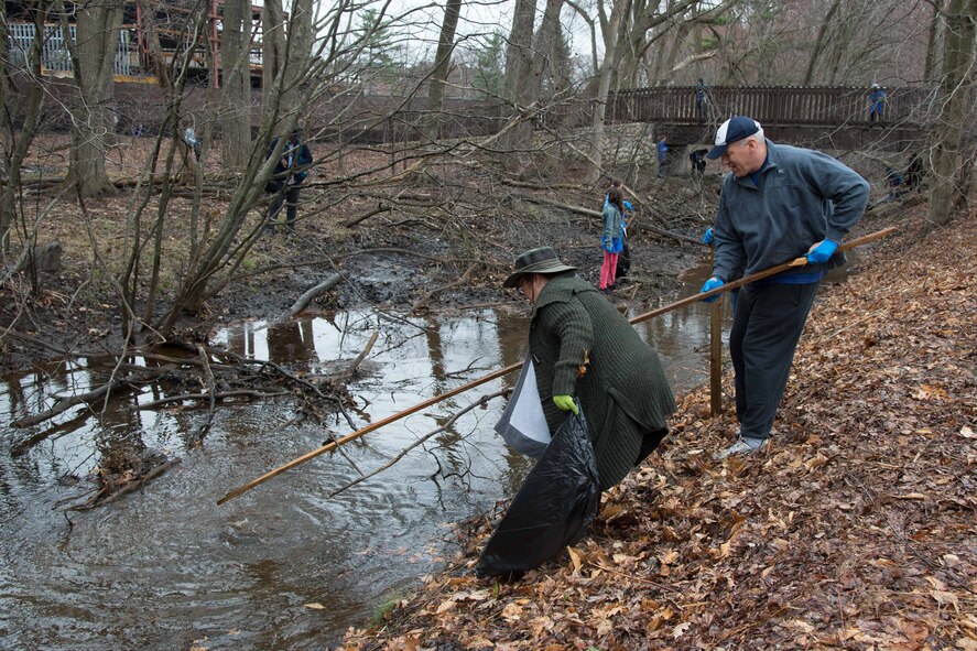 Deanne Guardino (left), Merrimack River Watershed Council director of development, and Tom Schluckebier, base civil engineer, remove trash from the Shawsheen River as part of an Earth Day River Cleanup project on base, April 17. Numerous volunteers from the base community, as well as sixth graders from the Hanscom Middle School, removed more than 17 bags of trash and debris from the river and the surrounding area. (U.S. Air Force photo by Mark Herlihy)