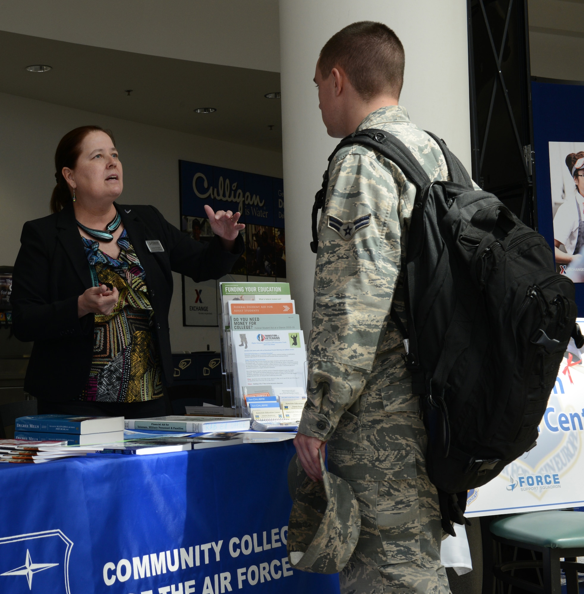 Annette Henderson, 86th Force Support Squadron Ramstein Education Center chief of education and training, answers questions for an Airman during the 86th FSS Ramstein Education Center Education Fair, April 16, 2015, at Ramstein Air Base, Germany. The purpose of the fair was to provide information about all the education programs offered at Ramstein. (U.S. Air Force photo/Airman 1st Class Tryphena Mayhugh)