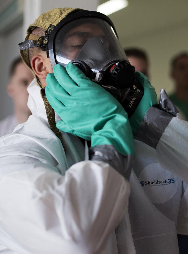 A student in the Hazardous Waste Operations and Emergency Response Course clears his mask during training outside of Building 100 aboard Marine Corps Air Station Iwakuni, Japan, April 16, 2015. This course is important for situations involving hazardous material because someone could put themselves, their department or the whole entire base at risk.