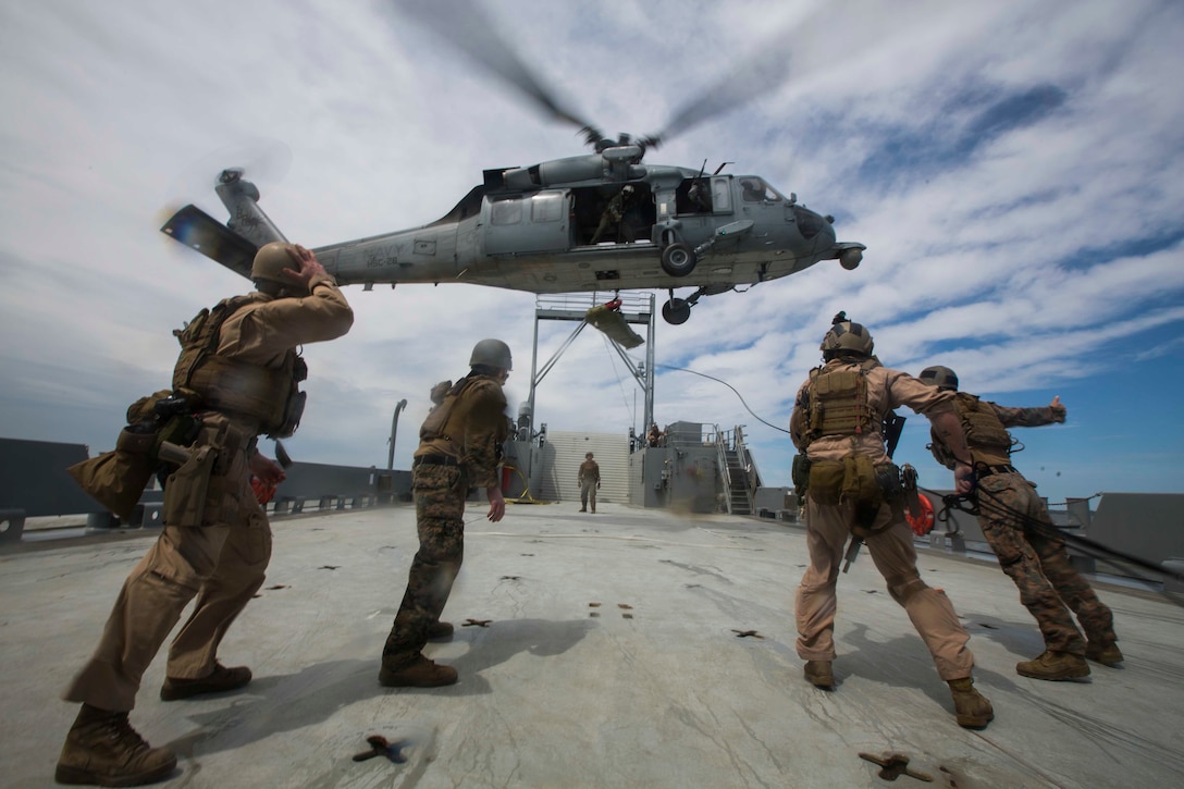 U.S. Marines and Sailors assigned to Force Reconnaissance Platoon, Maritime Raid Force, 26th Marine Expeditionary Unit (MEU) help lift a simulated casualty onto a SH-60 Seahawk during Visit, Board, Search, and Seizure (VBSS) training at Joint Base Langley-Eustis, Va., April 16, 2015. The Marines were evaluated on their training as part of preparation for deployment to the 5th and 6th Fleet Areas of responsibility later this year. (U.S. Marine Corps photo by Lance Cpl. Andre Dakis/26th MEU Combat Camera/Released)