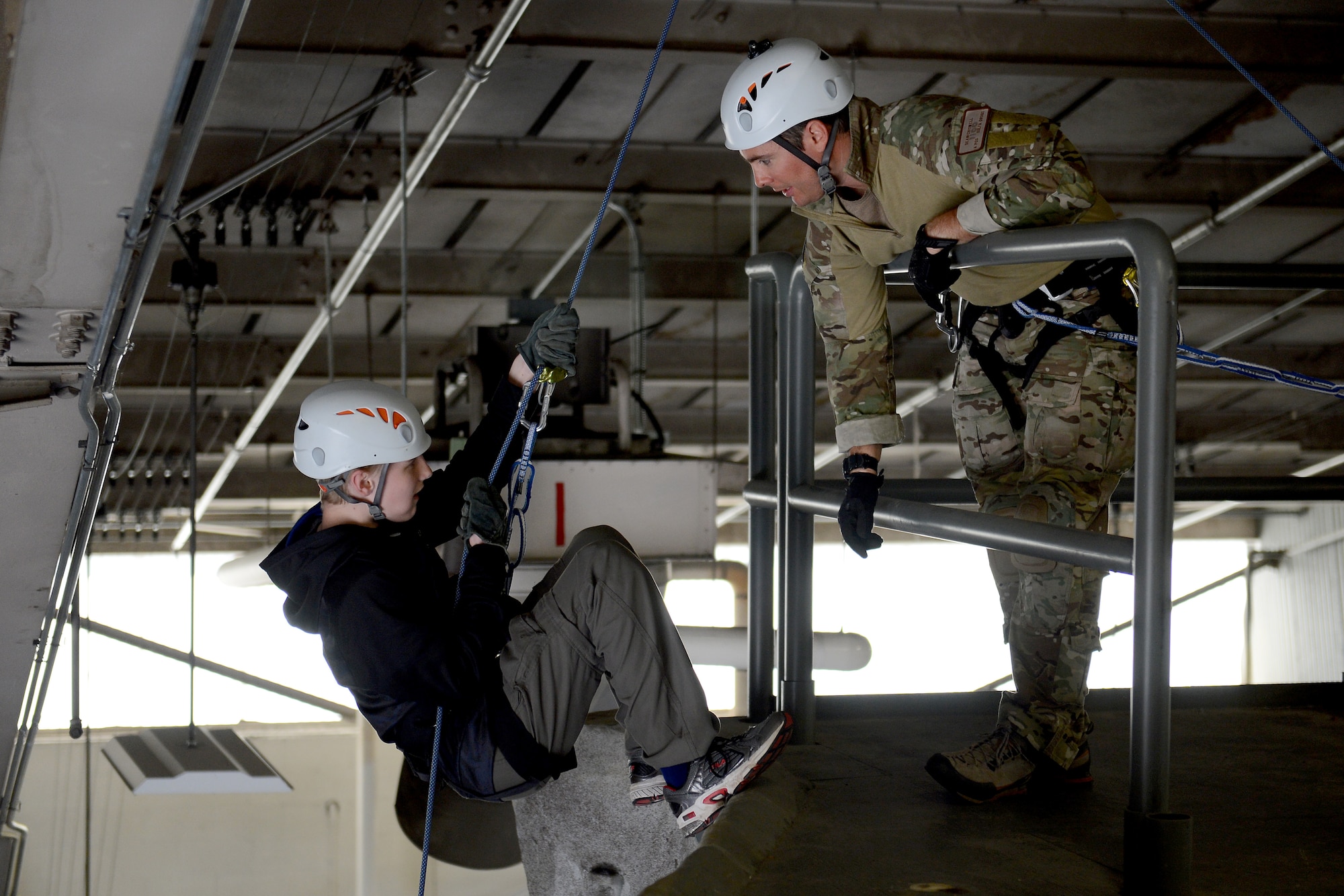 Tech. Sgt. Dean Criswell, 22nd Special Tactics Squadron pararescueman, gives instructions to a Boy Scout from Troop 007, April 18, 2015, at Joint Base Lewis-McChord, Wash. The boy scouts learned different techniques for setting up their harnesses to repel and the different equipment involved. (U.S. Air Force photo/Airman 1st Class Keoni Chavarria)