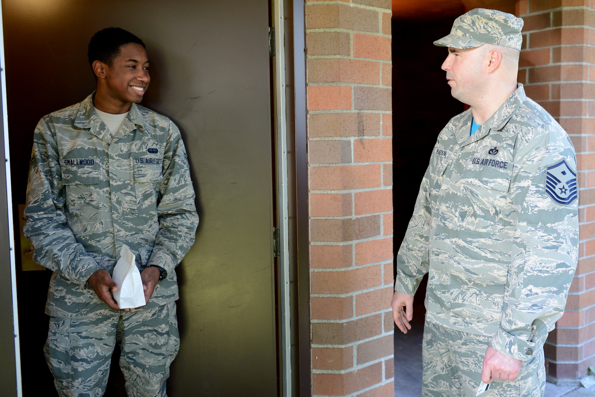 Master Sgt. Robert Peaden (right), 627th Communications Squadron first sergeant, talks to Airman 1st Class Iroquois Smallwood, 627th CS network administrator, after giving him cookies, April 17, 2015, at Joint Base Lewis-McChord, Wash. The cookies also gave first sergeants an opportunity to give back to the Airmen that live in the dorms and to have face-to-face conversations. (U.S. Air Force photo/Airman 1st Class Keoni Chavarria)
