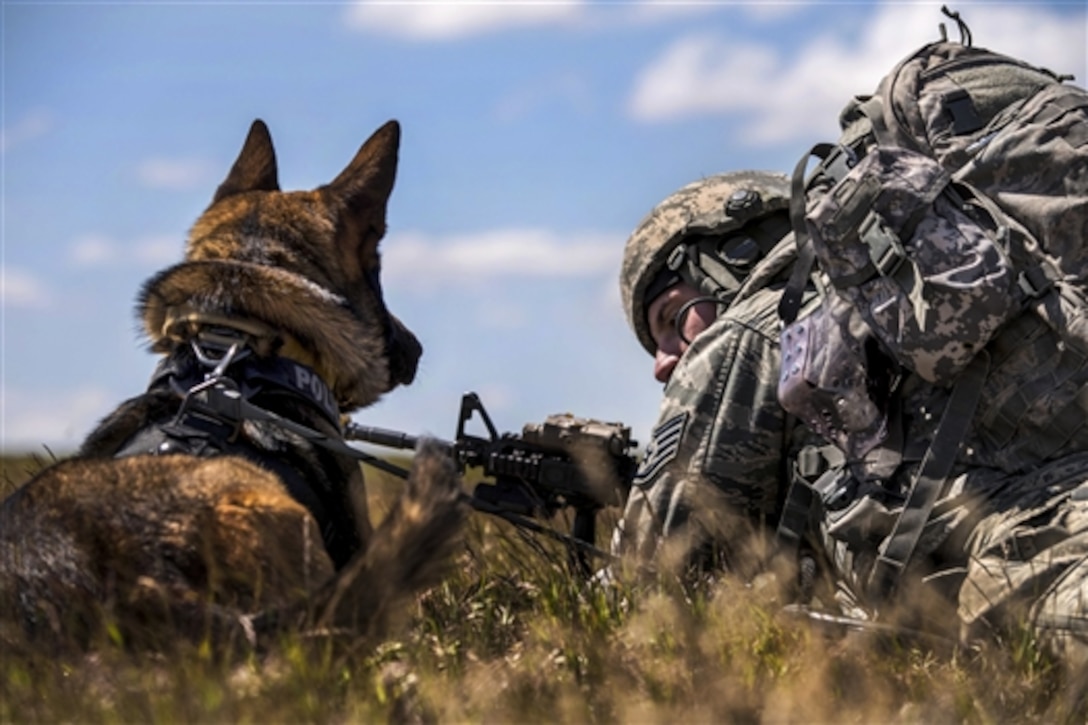 Air Force Staff Sgt. Joshua Rettschlag talks to his military dog, Onur, during Gunfighter Flag 15-2 on Saylor Creek Range, Idaho, April 15, 2015. Rettschlag is a military working dog handler assigned to the 366th Security Forces Squadron, which participated in the exercise to train in realistic scenarios with joint service members in a tactical environment.
