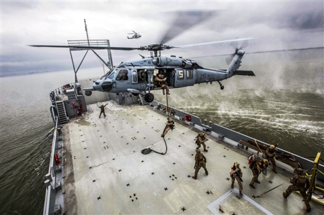 Marines fast-rope from an SH-60 Seahawk helicopter onto a ship during visit, board, search and seizure training off the coast of Joint Base Langley-Eustis, Va., April 14, 2015. The Marines are assigned to Force Reconnaissance Platoon, Maritime Raid Force, 26th Marine Expeditionary Unit.