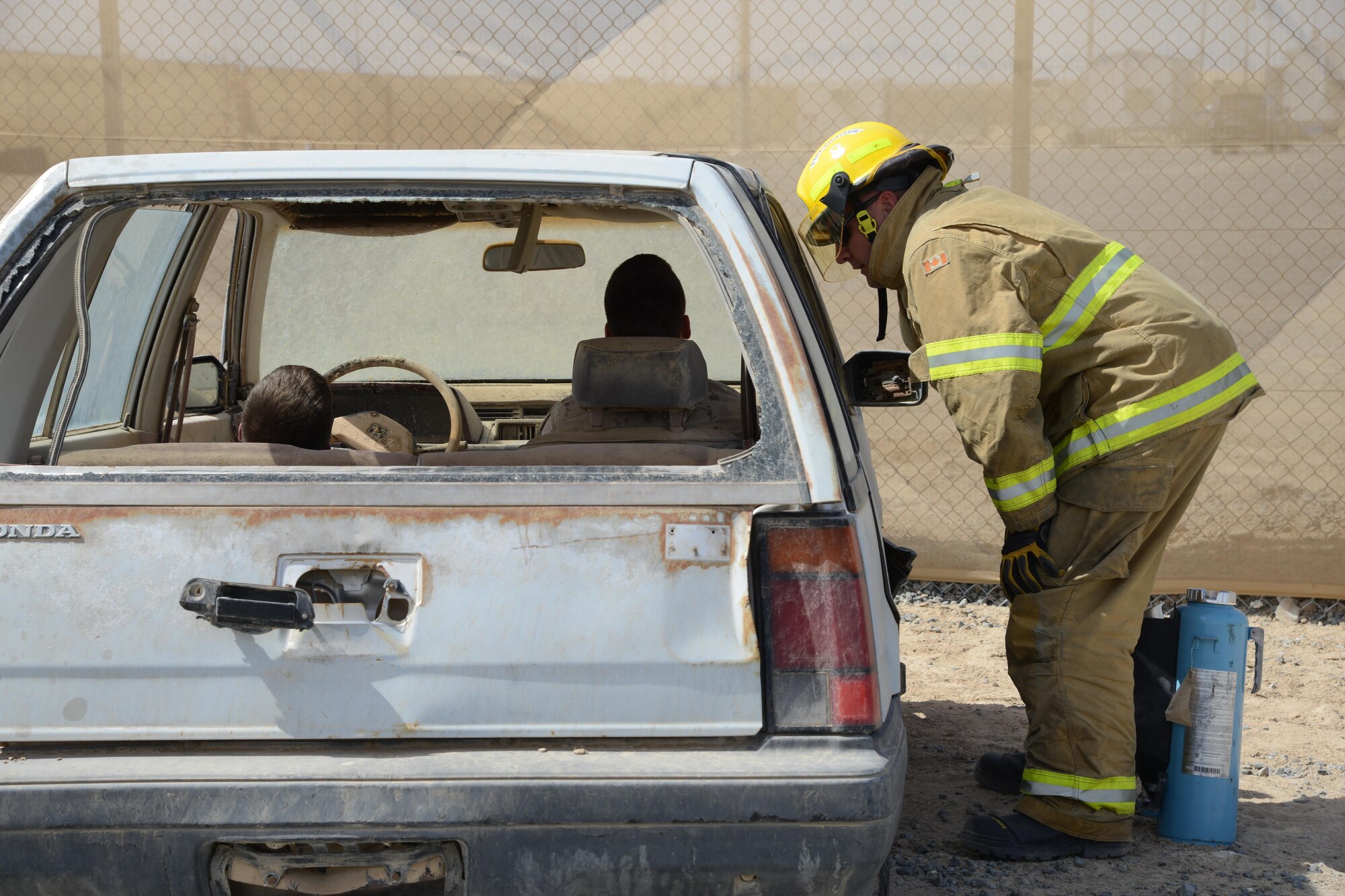 A Canadian firefighter checks on two victims of a simulated vehicle accident during a U.S. and Canadian emergency response exercise April 14, 2015. The exercise evaluated coalition coordination and response efforts of U.S. and Canadian emergency services. (U.S. Air Force photo by Tech. Sgt. Jared Marquis/released)