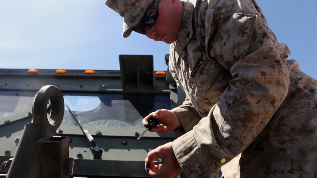 Lance Cpl. Donald Maddox, a motor transportation operator, with 1st Transport Support Battalion, Combat Logistics Regiment 1, 1st Marine Logistics Group, checks the oil in a Medium Tactical Vehicle Replacement during a routine maintenance inspection on the outskirts of Marine Corps Air Station Yuma, Arizona, April 10, 2015. Maddox inspects vehicles like this each day to ensure optimum reliability for logistic units supporting the bi-annual, seven-week long Weapons Tactics and Instructor course at MCAS Yuma and the surrounding area. WTI, hosted by Marine Aviation Weapons and Tactics Squadron 1, provides advanced tactical training to certify Marine pilots as weapons and tactics instructors, preparing them to serve in key training officer billets in the fleet Marine force. (Marine Corps photo by Sgt. Cody Haas/Released)