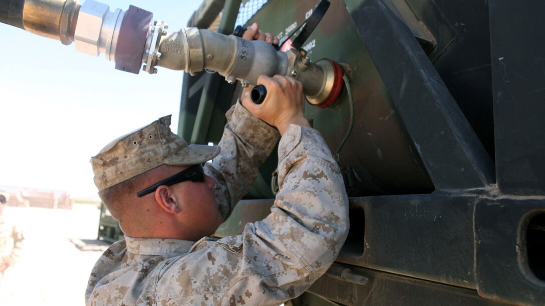 Private First Class Brenen Tischner, a motor transportation operator, with 1st Transport Support Battalion, Combat Logistics Regiment 1, 1st Marine Logistics Group, attaches a fuel hose to an AMK-23 Medium Tactical Vehicle Replacement during routine refueling maintenance on the outskirts of Marine Corps Air Station Yuma, Arizona, April 10, 2015. Tischner inspects vehicles like this each day to ensure optimum reliability for logistic units supporting the bi-annual, seven-week long Weapons Tactics and Instructor course at MCAS Yuma and the surrounding area. WTI, hosted by Marine Aviation Weapons and Tactics Squadron 1, provides advanced tactical training to certify Marine pilots as weapons and tactics instructors, preparing them to serve in key training officer billets in the fleet Marine force. (Marine Corps photo by Sgt. Cody Haas/Released)