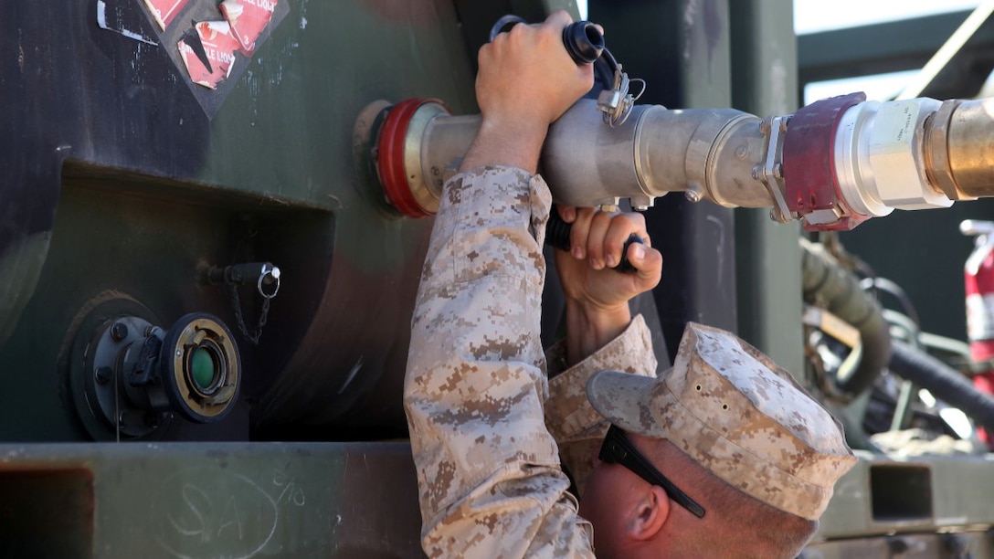 Private First Class Brenen Tischner, a motor transportation operator, with 1st Transport Support Battalion, Combat Logistics Regiment 1, 1st Marine Logistics Group, attaches a fuel hose to an AMK-23 Medium Tactical Vehicle Replacement during routine refueling maintenance on the outskirts of Marine Corps Air Station Yuma, Arizona, April 10, 2015. Tischner inspects vehicles like this each day to ensure optimum reliability for logistic units supporting the bi-annual, seven-week long Weapons Tactics and Instructor course at MCAS Yuma and the surrounding area. WTI, hosted by Marine Aviation Weapons and Tactics Squadron 1, provides advanced tactical training to certify Marine pilots as weapons and tactics instructors, preparing them to serve in key training officer billets in the fleet Marine force. (Marine Corps photo by Sgt. Cody Haas/Released)