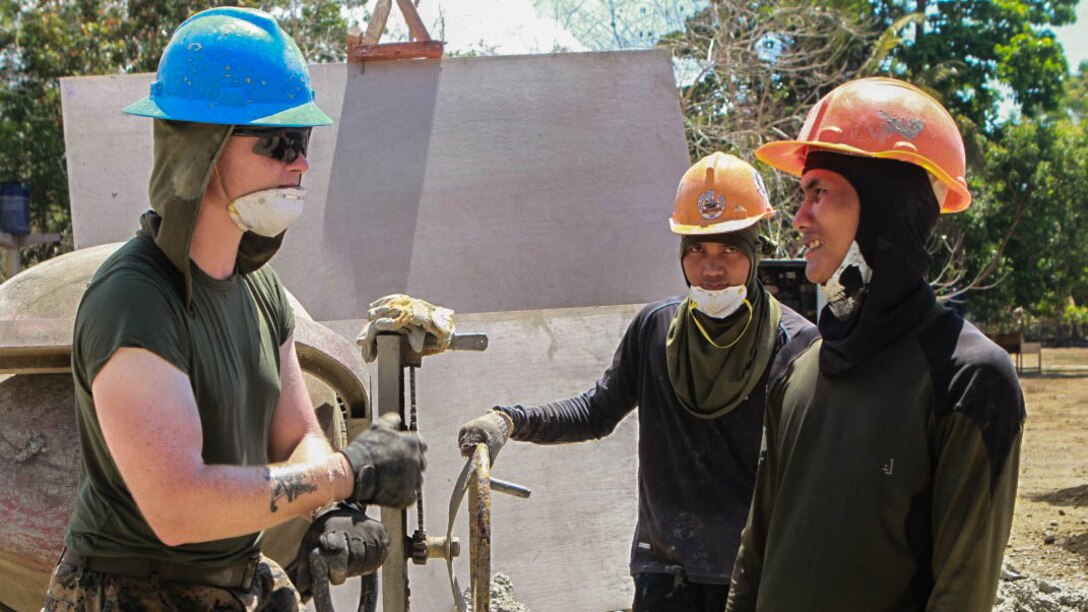 U.S. Marine Lance Cpl. Andrew Sprouse, left, a combat engineer with 9th Engineer Support Battalion, 3rd Marine Logistics Group, III Marine Expeditionary Force, introduces himself to Philippine Navy Seaman Apprentices Raymond Baclason, center, and Arturo Arandela, both Seabees with the Armed Forces of the Philippines’ 2nd Naval Mobile Construction Battalion, at the site of a new classroom they are helping build at San Rafael Elementary School in San Rafael, on the island of Palawan, Philippines, April 16. The three are part of a larger group of service members from the AFP and U.S. militaries, constructing five new buildings across the island of Palawan as part of humanitarian civic assistance projects taking place during exercise Balikatan 2015. Balikatan, a Filipino word meaning "shoulder-to-shoulder," is an annual bilateral exercise with the AFP and U.S. militaries, which helps increase combined military-to-military training and build relationships in order to support future engagements. (