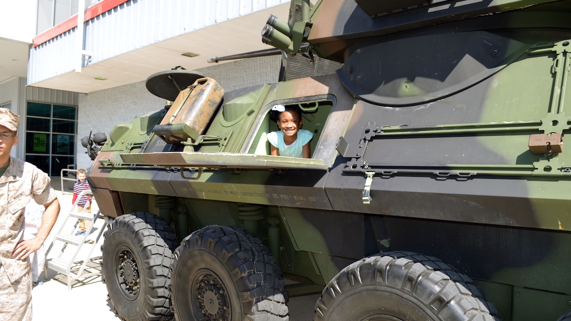Saryi, age 9, looks out of the side hatch of a light armored vehicle April 18 at Marine Corps Base Quantico, Virginia. In honor of the Month of the Military Child, Marines from Delta Company, 4th Light Armored Reconnaissance Battalion, brought the LAV to the parking lot of the main exchange for children to explore.