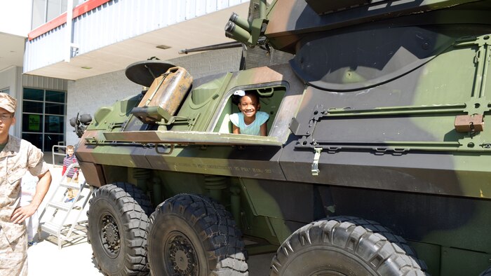 Saryi, age 9, looks out of the side hatch of a light armored vehicle April 18 at Marine Corps Base Quantico, Virginia. In honor of the Month of the Military Child, Marines from Delta Company, 4th Light Armored Reconnaissance Battalion, brought the LAV to the parking lot of the main exchange for children to explore.