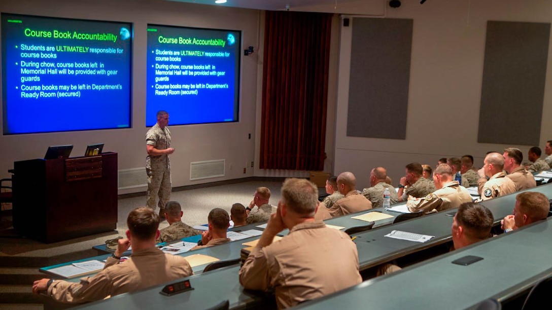 U.S. Marines, students attending Weapons and Tactics Instructor Course 1-15, are given a check-in brief by 1st Lt. Richard Hayek, Adjutant, Marine Aviation Weapons and Tactics Squadron One, Aug. 31, 2014.The course is a seven-week training event hosted by the squadron's cadre. The squadron provides standardized tactical training and certification of unit instructor qualifications to support Marine aviation training and readiness and assists in developing and employing aviation weapons and tactics. 