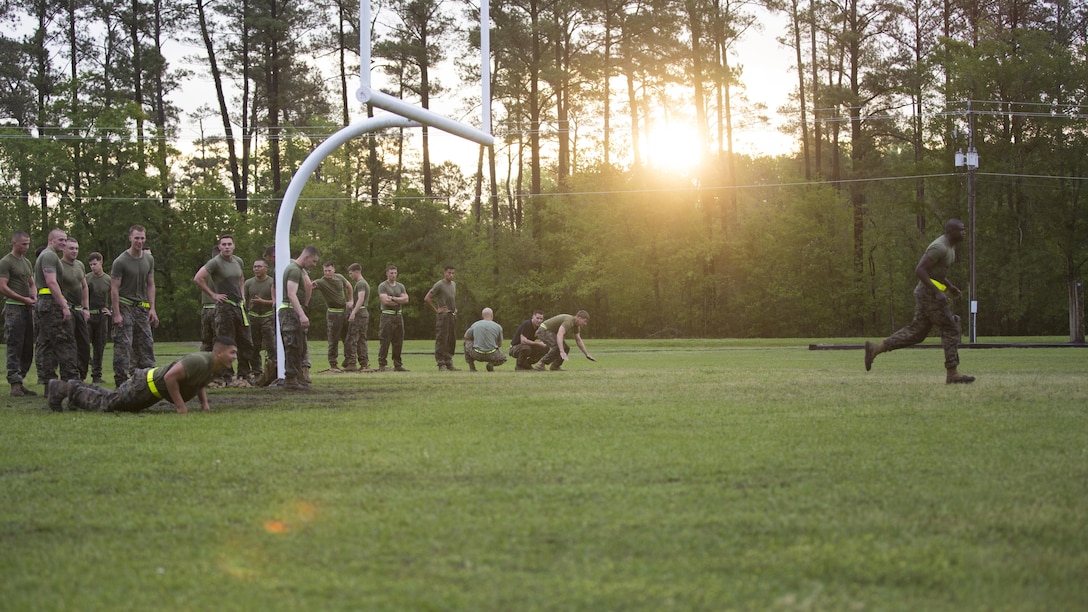 Marines from various units with the Advanced Machine Gunner Course, Advanced Infantry Training Battalion-East, participate in a physical training event to begin their day during AMGC, aboard Camp Geiger, N.C., April 20, 2015. The purpose of this course is to bring the Marines back to the machine-gunner fundamentals and further develop their skills so they can bring this refreshed knowledge back to their units.