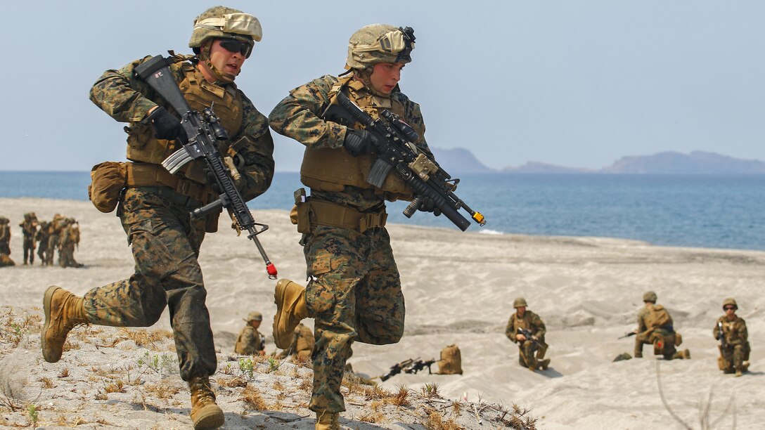 U.S. Marines with 3rd Marine Regiment quickly return to their Amphibious Assault Vehicle to grab extra equipment needed on the firing line, April 21, during a bilateral amphibious landing by the Philippine and U.S. Marines on North Beach at the Naval Education Training Center in Zambales, Philippines, as part of exercise Balikatan 2015. Designed to assault any shoreline from the well decks of Navy assault ships, AAVs are highly mobile, tracked armored amphibious vehicles that transport Marines and cargo to and through hostile territory. Balikatan, which means “shoulder-to-shoulder” in Filipino, is an annual bilateral training exercise held since 1984, aimed at improving the ability of Philippine and U.S. military forces to work together during planning, humanitarian assistance and disaster relief operations. 