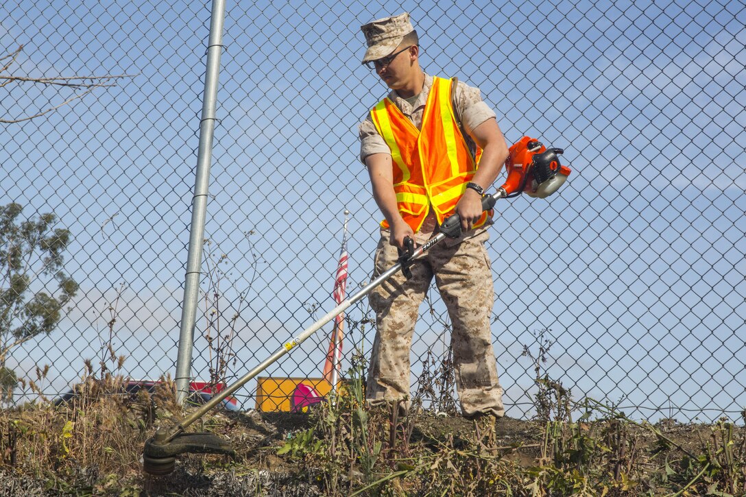 Cpl. Devyn Perkins, a maintenance manager with Marine Wing Headquarters Squadron (MWHS) 3, uses a weed whacker during a station-wide cleanup aboard Marine Corps Air Station Miramar, California, April 20. More than 250 service members were divided into six groups and each group was responsible for cleaning a sector of the base.