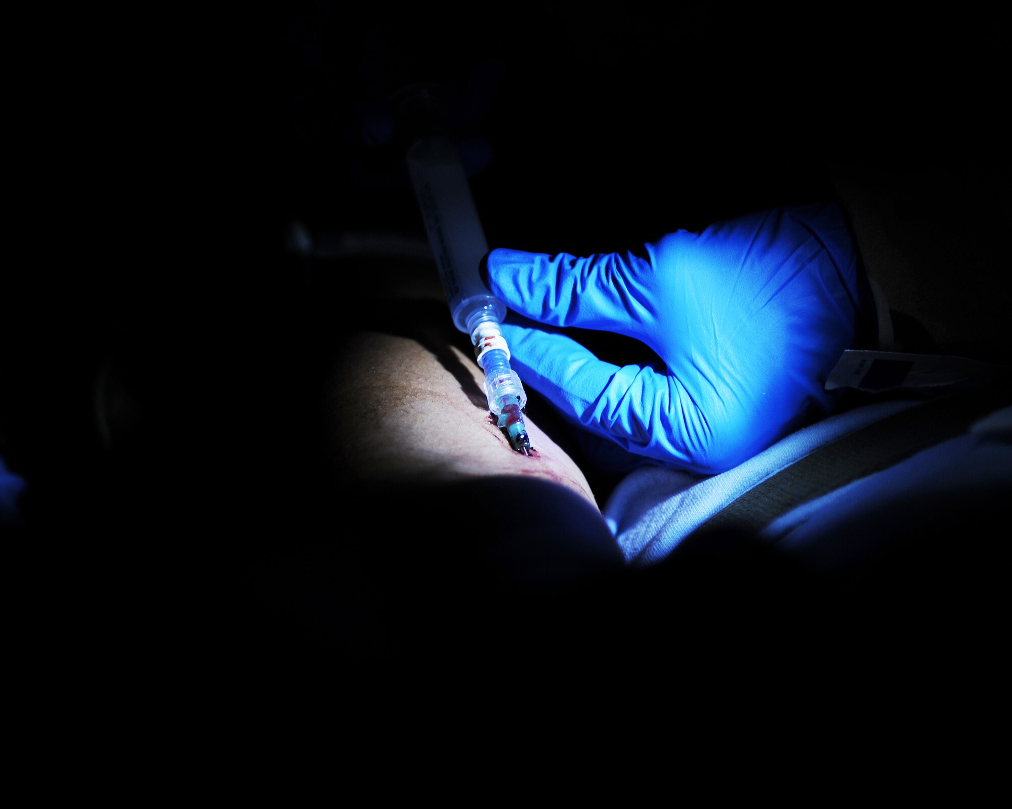 U.S. Air Force Capt. Maria Vazquez, 455th Expeditionary Aeromedical Evacuation Squadron flight nurse, adjusts a patient’s intravenous needle during an AE mission April 19, 2015 at Kandahar Airfield, Afghanistan. 455 EAES Airmen are charged with the responsibility of evacuating the sick and wounded from Central Command to higher echelons of medical care. (U.S. Air Force photo by Staff Sgt. Whitney Amstutz/released)