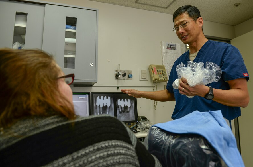 Maj. Jongsun Kim, 374th Dental Squadron Endodontics chief, explains the results of his patient’s dental surgery April 16, 2015 Yokota Air Base, Japan. After three hours, Kim was able to clear out the infection and seal off the canals at the base of the patient’s roots. (U.S. Air Force photo by Airman 1st Class Elizabeth Baker/Released)
