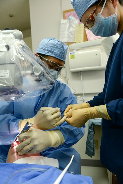 374th Dental Squadron chief of Endodontics, Maj. Jongsun Kim, applies sealant to a tool with assistance from Reina Aikawa, dental assistant, during a root-end surgery April 16, 2015 Yokota Air Base, Japan. Aikawa is familiar with the procedure, and is prepared to assist Kim on the next step without being asked. (U.S. Air Force photo by Airman 1st Class Elizabeth Baker/Released)